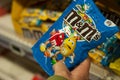 Closeup of chocolate-coated peanuts from M & m`s brand in hand at Super U supermarket