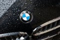 rain drops on BMW logo on black car front parked in the street, BMW is the famous luxury brand of german cars Royalty Free Stock Photo