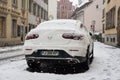 Rear view of white Mercedes SUV car covered by the snow parked in the street Royalty Free Stock Photo