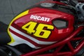 Closeup of Ducati logo on red tank of motorbike parked in the street