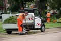 Gardener picking cutted grass and dead leaves in urban park