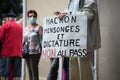 Man protesting in the street against the sanitary pass with banner in french Macron mensonges dictature, in english : MAcron lies