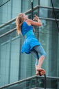 Portrait of a young blond woman climbing rope for an outdoor aerobatics show in Mulhouse