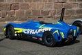 Profile view of blue soapbox car parked in the street after the race