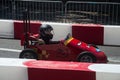 Profile view of red soapbox car parked in the street during the race