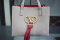 Beige leather handbag by Valentino in a luxury fascion store showroom