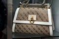 Closeup of brown leather hand bag by Guess in a luxury fashion store showroom