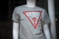 grey teee-shirt by GUESS on mannequin in a fashion store showroom