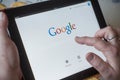Closeup of woman hands on Google home page search of web site on tablet