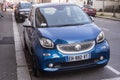 Front view of blue smart car parked in the street