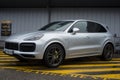 Front view of grey Porsche cayenne parked in the street by rainy day