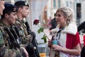 Portrait of miss of carnival speaking to military people with a red rose in hand