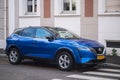 profile view of blue Nissan qashqai parked in the street