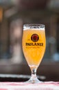 Closeup of glass of french beer from Paulaner` brand at restaurant terrace