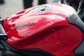 Closeup of Triumph logo on red motorbike parked in the street