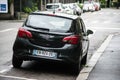 Rear view of black Opel Corsa parked in the street by rainy day