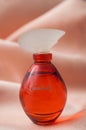Cantate perfume in a red bottle on satin background Royalty Free Stock Photo
