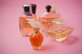 Miniature bottles of luxury perfume of various brands on pink background