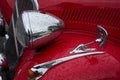 Closeup of rain drops on headlight of red Citroen traction parked in the street
