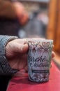 Mulled wine in traditional cup in hand of woman on wooden table at the christmas market Royalty Free Stock Photo