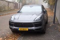 Front view of grey porsche cayenne, the famous green suv car parked in the street