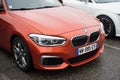 Front view of orange BMW 2 series parked in the street Royalty Free Stock Photo