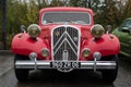 Front view of red Citroen traction parked in the street by rainy day