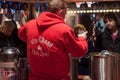 man giving a cup of mulled wine at the christmas market