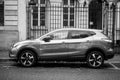 Profile view of grey Nissan SUV car parked in the street