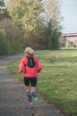 Woman running alone on the road in autumn