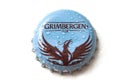 Drops on blue Grimbergen bier capsule on white background