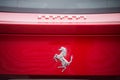 Closeup of the famous horse logo on the rear of red ferrari car parked in the street