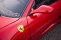 Closeup of ferrari logo on red luxury sport car parked in the street