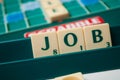 Plastic letters on Scrabble board game forming the word : Job