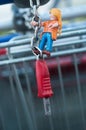 Playmobil figurine climbing on metallic trolley of supermarket