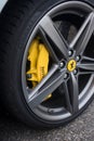 Closeup of yellow brake on the wheel of ferrari car parked in the street