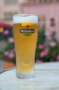 Closeup of glass of french beer from Heineken brand at restaurant terrace