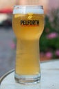 Closeup of glass of french beer from Pelfort brand at restaurant terrace