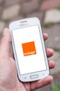 Closeup of Orange logo on smartphone screen in hand from Samsung brand in the street