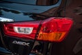 Rear light and sign on black Mitsubishi crossover parked in the street