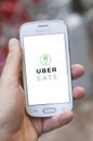 Closeup of Uber Eats logo on Smartphone in hand in the street Royalty Free Stock Photo