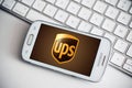 Closeup of ups logo on smartphone screen from Samsung brand on white keyboard background