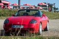 Front view of red Fiat Barchetta roadster parked at the top of the mountain