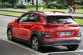 Rear view of orange color Hyundai Kona parked in the street