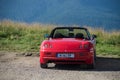 Rear view of red Fiat Barchetta roadster parked at the top of the mountain