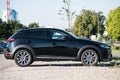 Profile view of black Mazda CX3 crossover parked in the street