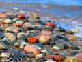 Mulitcolored rocks on lake`s edge with surf close-up Royalty Free Stock Photo