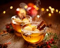 Mulled cider with slice apples, cinnamon, cloves, anise stars and citrus fruits in glass cups on a wooden rustic table, close-up. Royalty Free Stock Photo