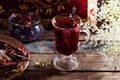 Mulled wine with a badge and cardamom in a glass on a wooden table top