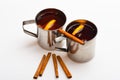 Mulled wine or beverage with cinnamon. Mugs with mulled wine or hot drink and cinnamon aroma sticks, white background